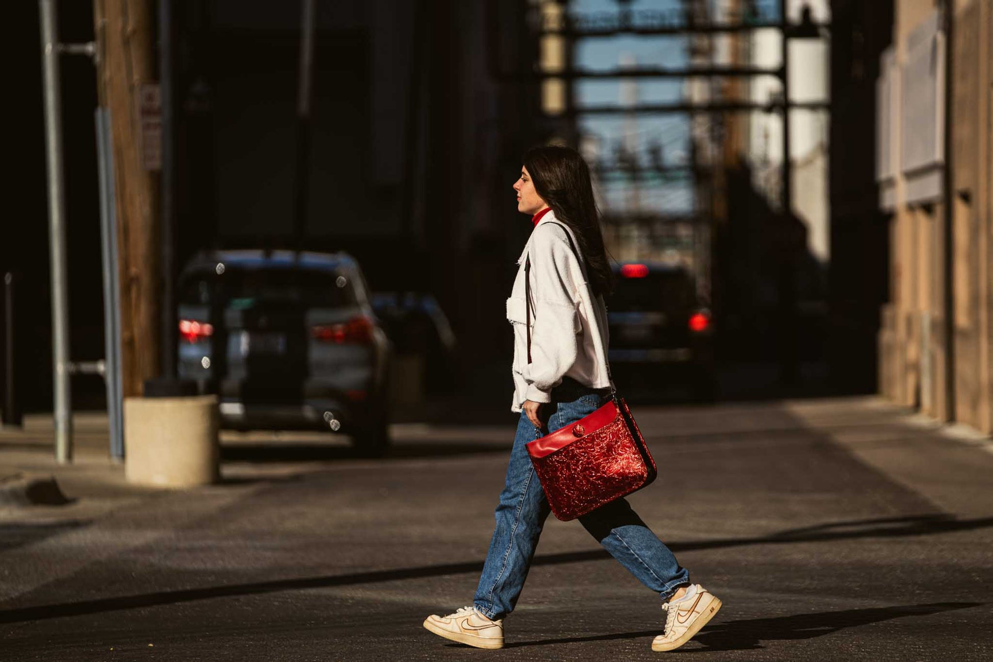 woman walking with red leather purse