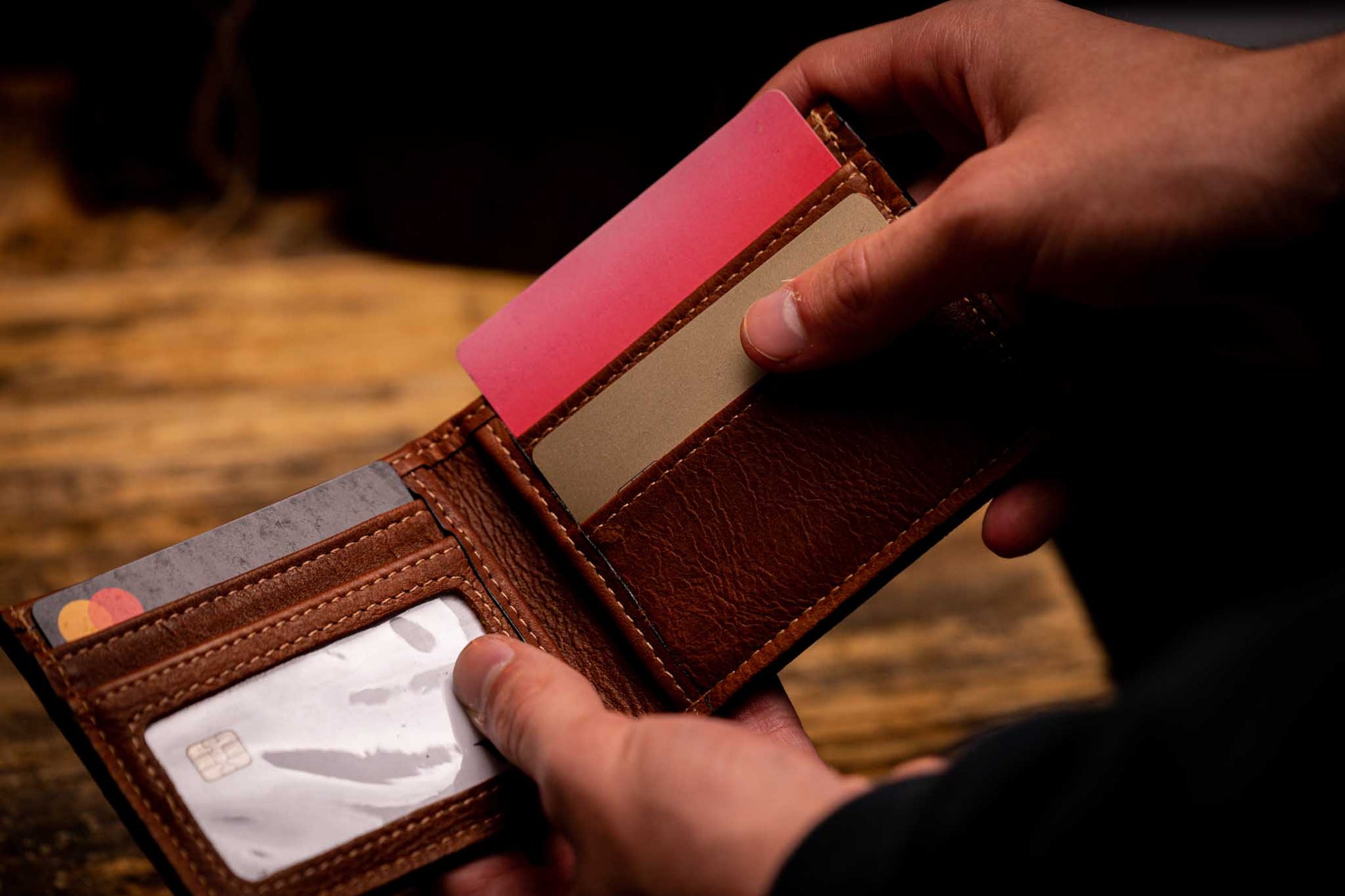 Person holding brown leather bifold wallet