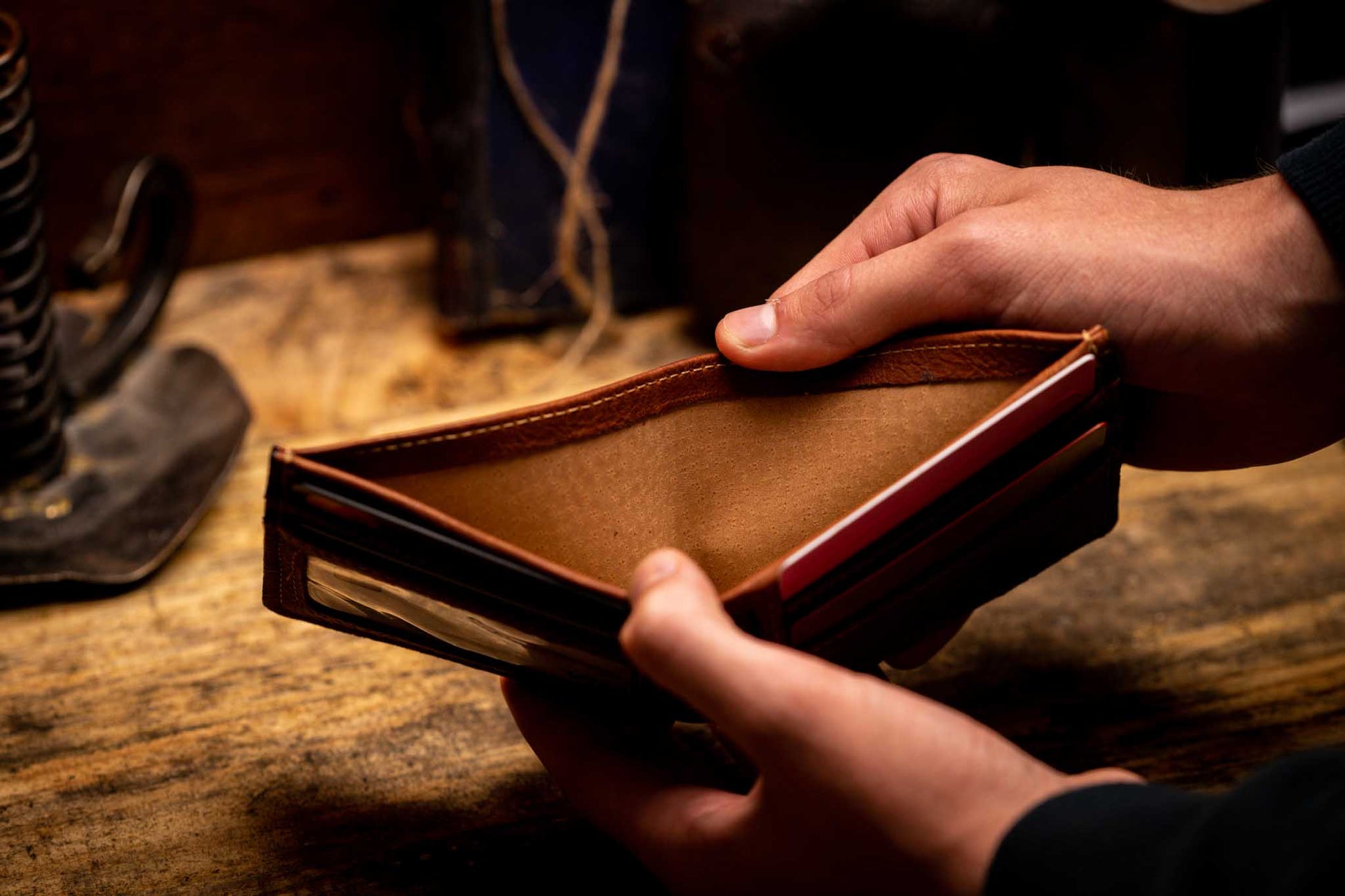 person opening brown leather bifold wallet