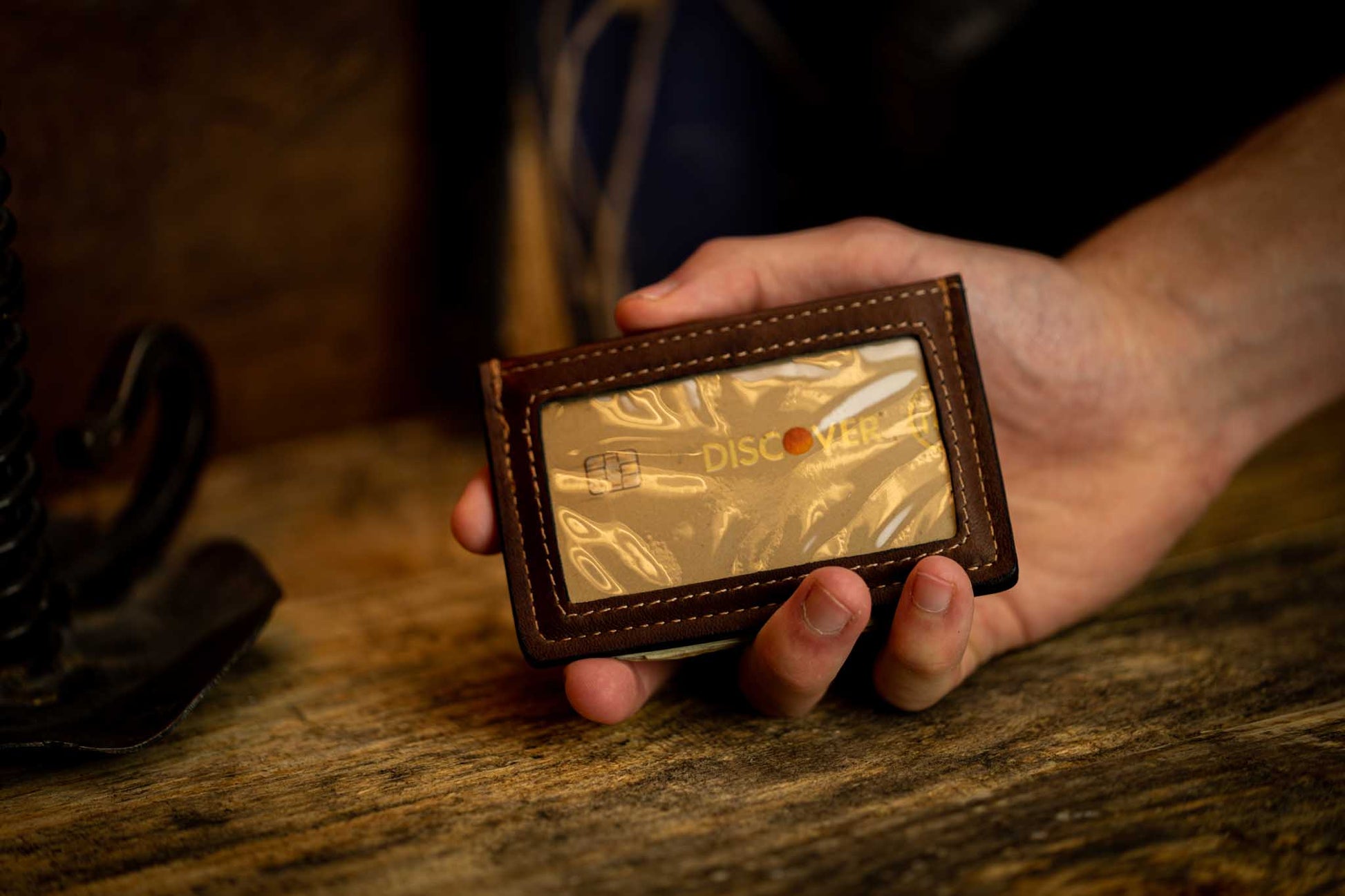 Hand holding brown leather money clip